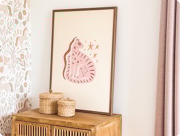 A frame with a cat standing on a nightstand